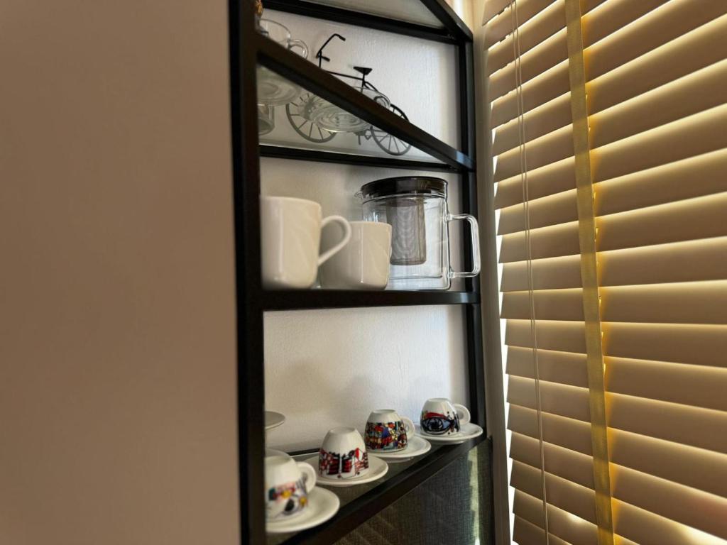 a shelf with cups and saucers on it at Seanest Greencoast in Himare