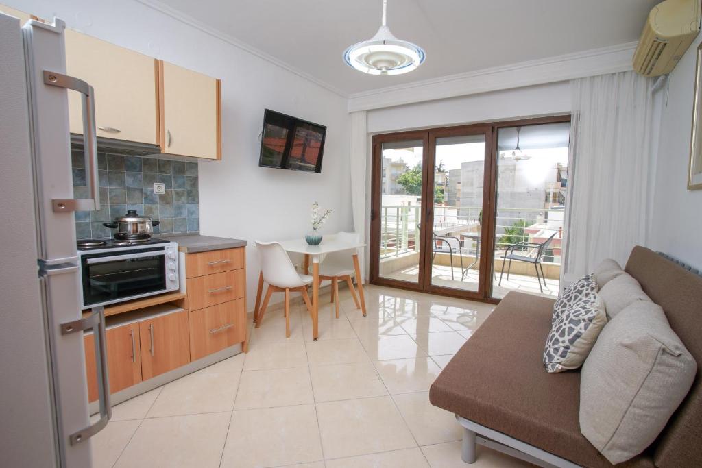 a kitchen and living room with a couch and a table at Work of Art apartment in Nea Michaniona in Néa Michanióna