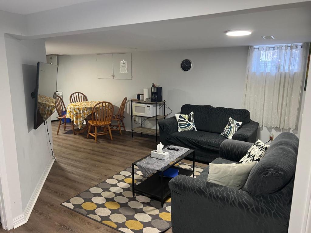 a living room with two couches and a table at Cozy basement 2 bedroom 2 bath with parking in Richmond Hill