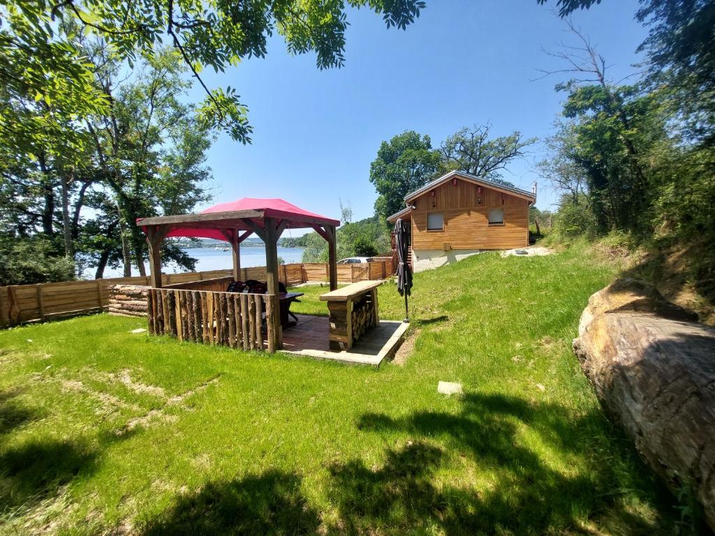 un gazebo con tavolo da picnic e una cabina di Le Chalet de la Femme du Pêcheur a Peigny
