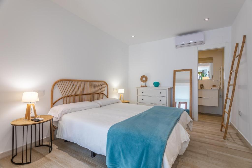 una camera da letto con un letto grande con una coperta blu di Malabau Beach House a Tarifa
