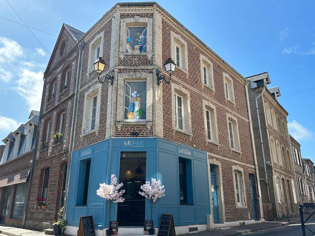 a large brick building with a blue storefront at Villa Jade Etretat in Étretat