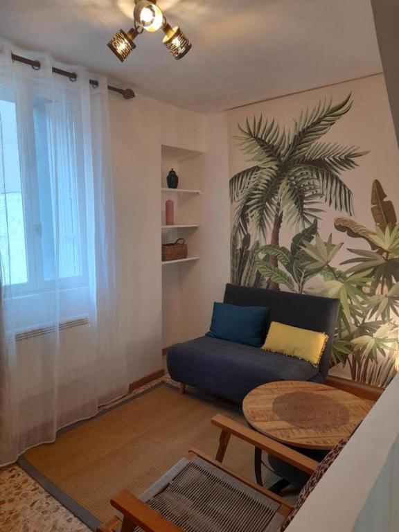 un salon avec un canapé bleu et une table dans l'établissement Appart Yucca, à Lézignan-Corbières