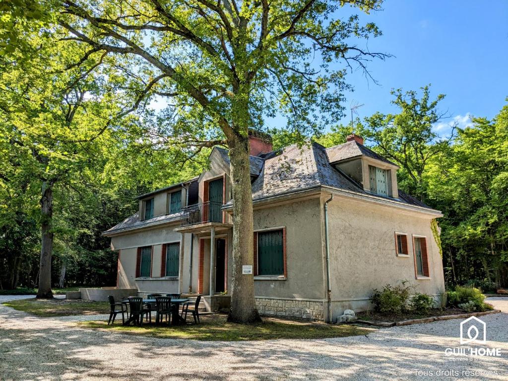 una vecchia casa con un tavolo da picnic di fronte di Les Chênes - Climatisation - Spacieux - Nature a Boigny-sur Bionne