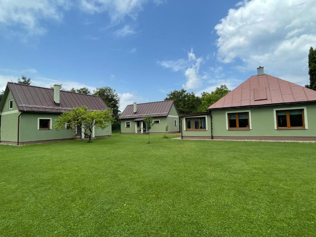 ein Haus mit einem grünen Rasen davor in der Unterkunft AURUM resort in Štiavnické Bane