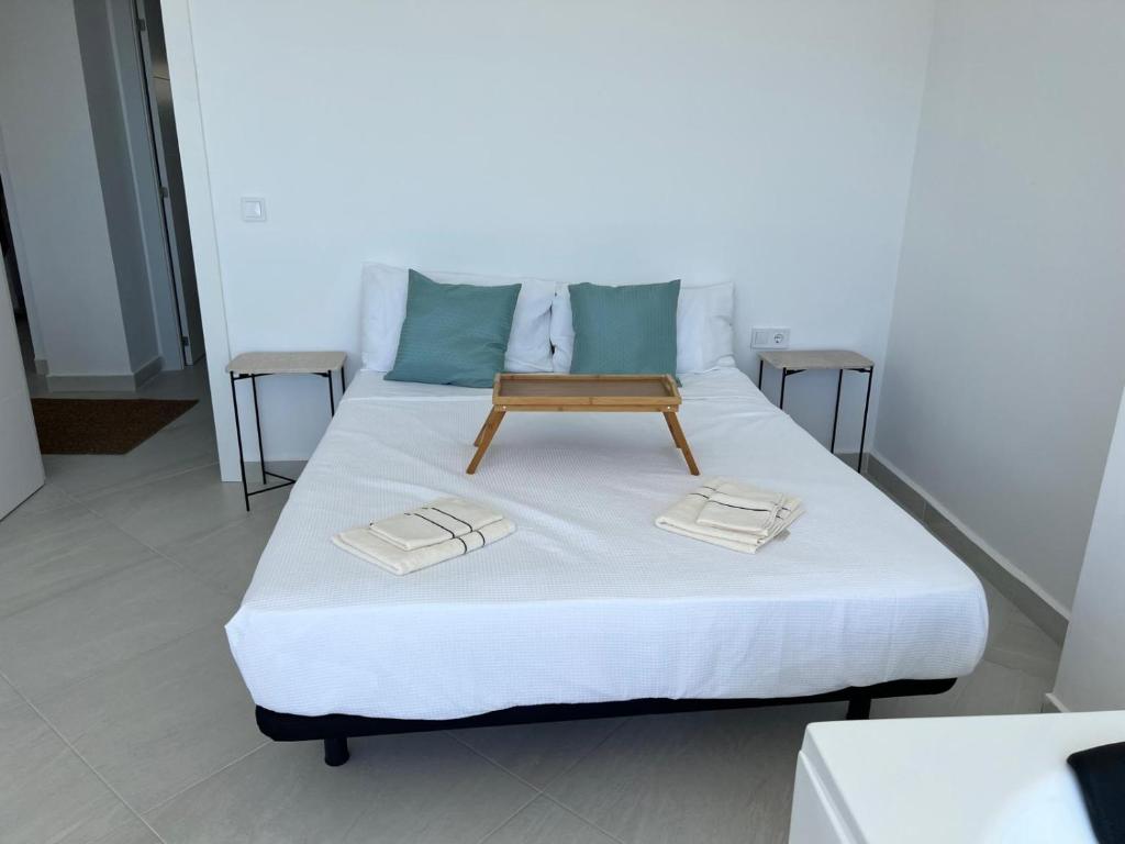 Una cama con una bandeja de madera encima. en Modern apartment sea view with private jacuzzi, en Villajoyosa