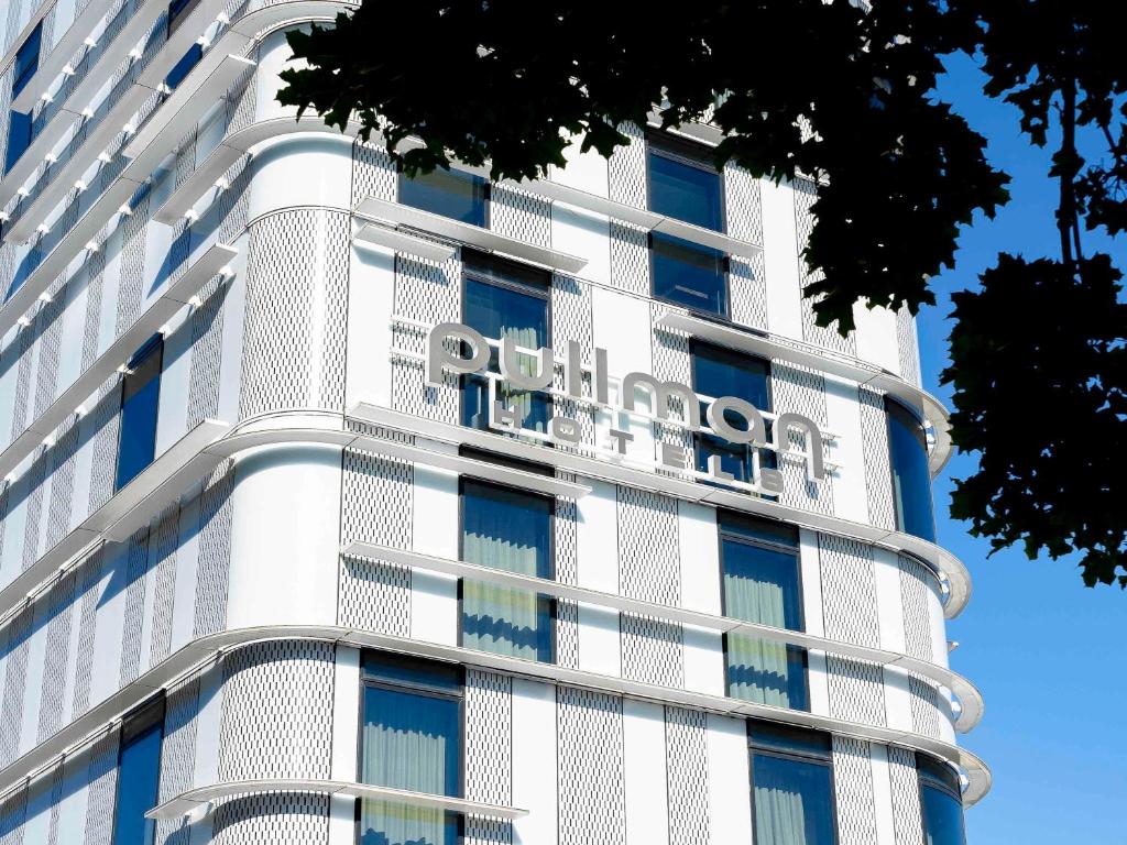 a white building with a sign on it at Pullman Paris Roissy Cdg Airport in Roissy-en-France
