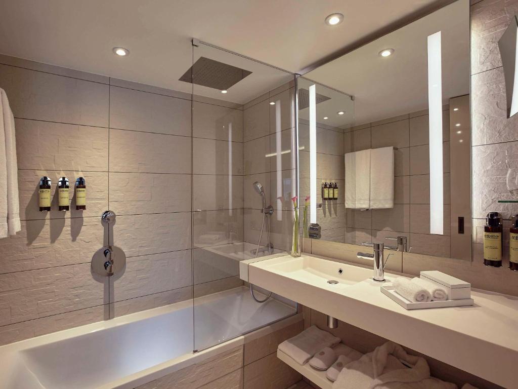 a large bathroom with a tub and a sink at Pullman Paris Roissy Cdg Airport in Roissy-en-France