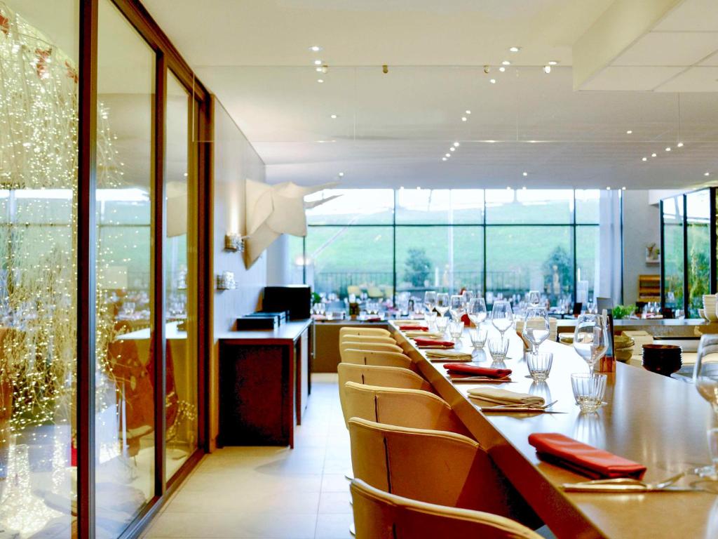 a dining room with a long table and chairs at Pullman Paris Roissy Cdg Airport in Roissy-en-France