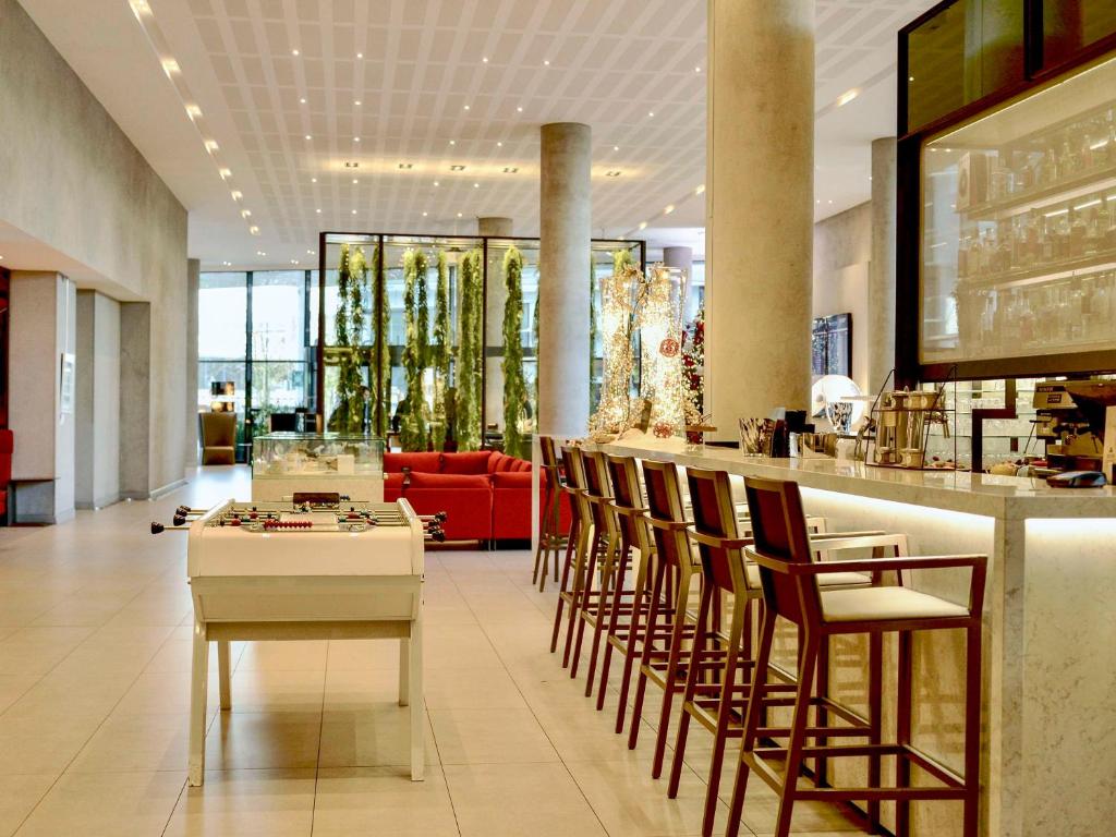 a restaurant with a white table and chairs at Pullman Paris Roissy Cdg Airport in Roissy-en-France