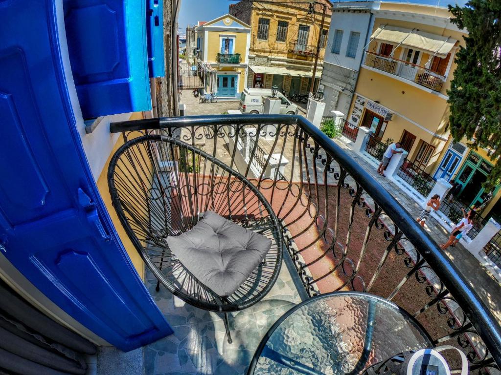 a chair sitting on a balcony with a street at Duchess House in Symi