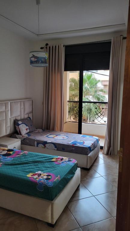 two beds sitting in a room with a window at السعيدية in Saidia 