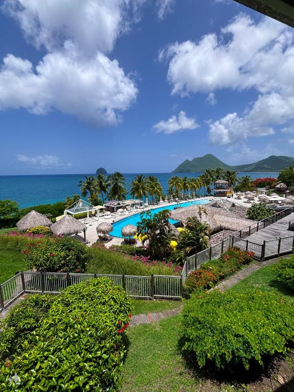 vista su un resort con piscina e oceano di Studio Ti Saphir a Le Diamant