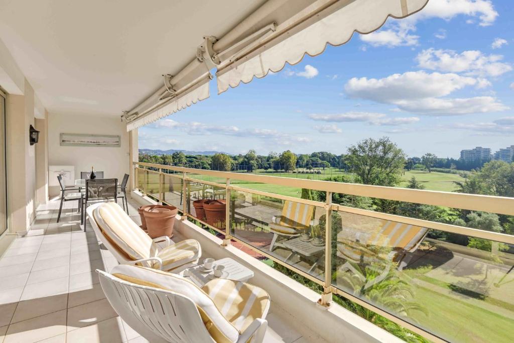d'un balcon avec des chaises et une vue sur un champ. dans l'établissement T3 in Mandelieu with Terrace AC Parking Swimming Pool Tennis - BENAKEY, à Mandelieu-la-Napoule