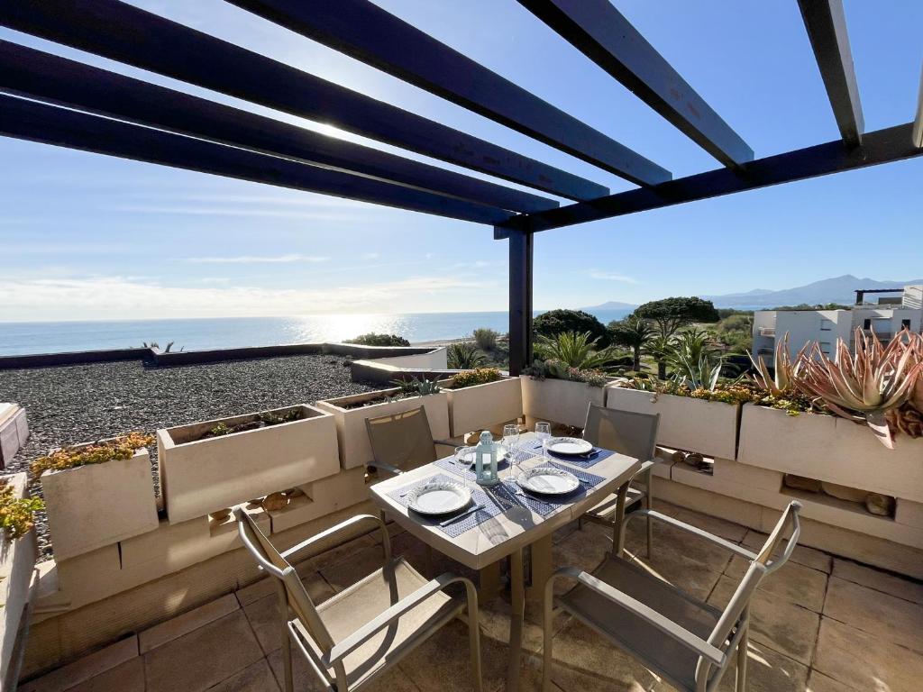 un patio avec une table et des chaises sur un balcon dans l'établissement Saint-Cyprien : Appt front de mer avec piscine, parking et clim - FR-1-753-25, à Saint-Cyprien