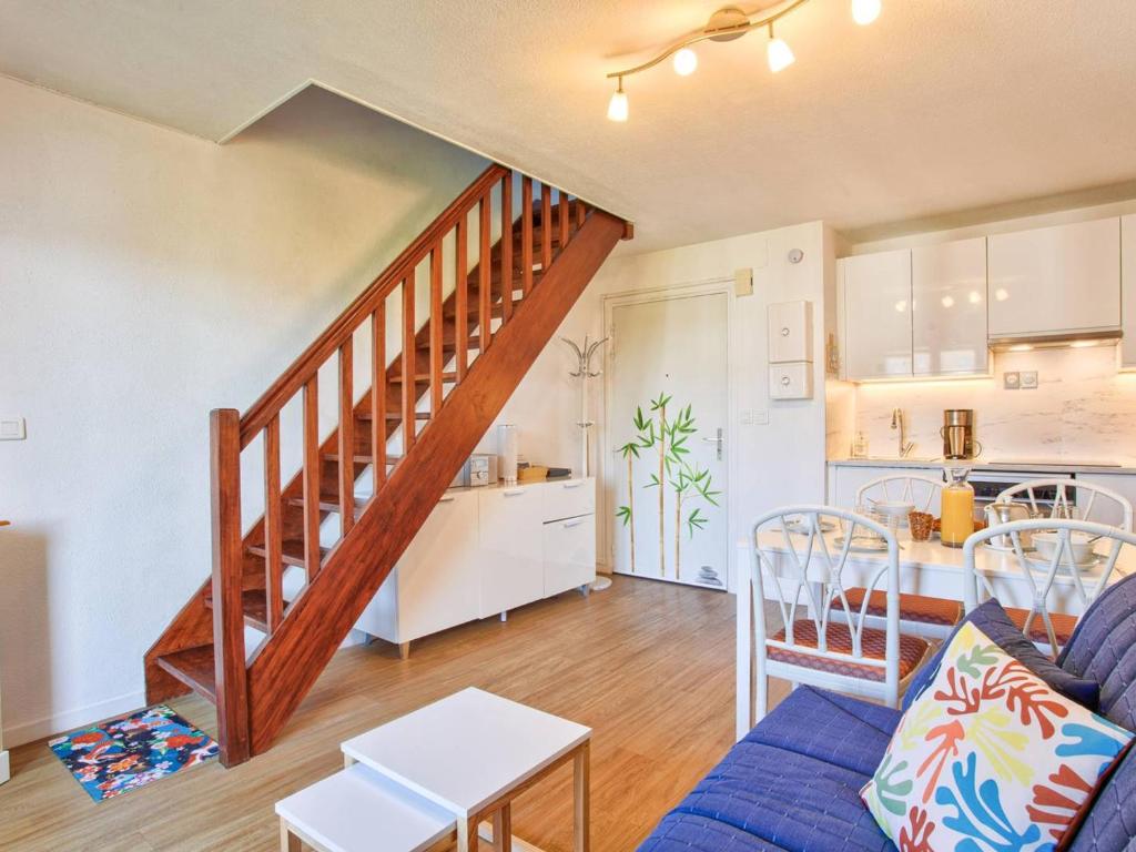 un salon avec un escalier et une cuisine dans l'établissement Appartement lumineux avec balcons et stationnement privatif - FR-1-788-22, à Varaville