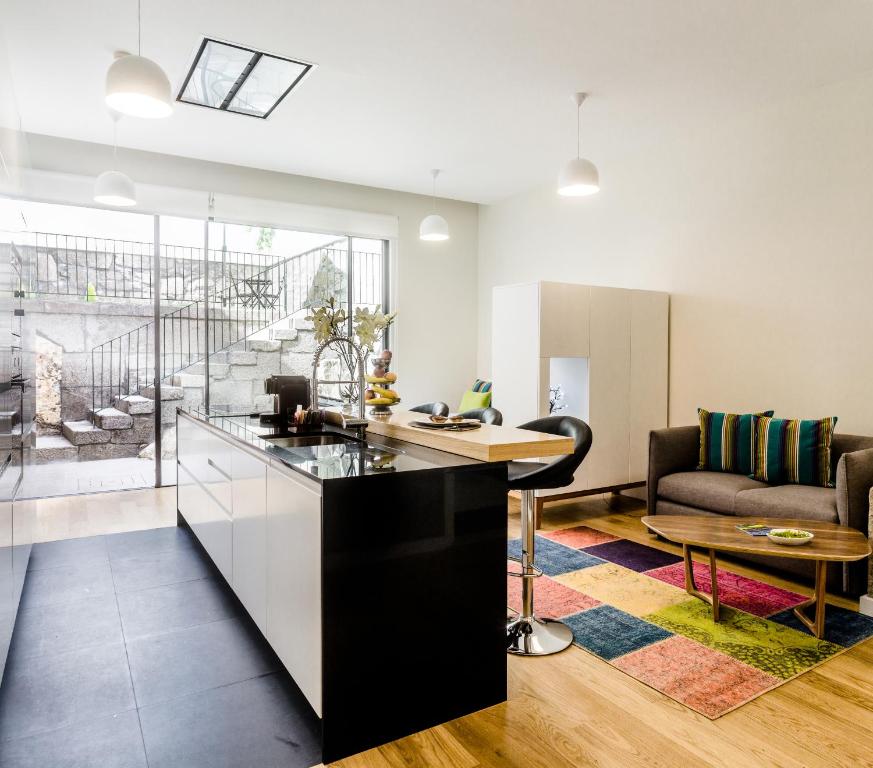 a kitchen and living room with a couch and a table at Oportolazaro Apartment in Porto