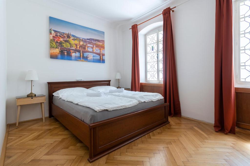 Un dormitorio con una cama y dos ventanas. en Historic Spirit at Studio under the Prague Castle, en Praga