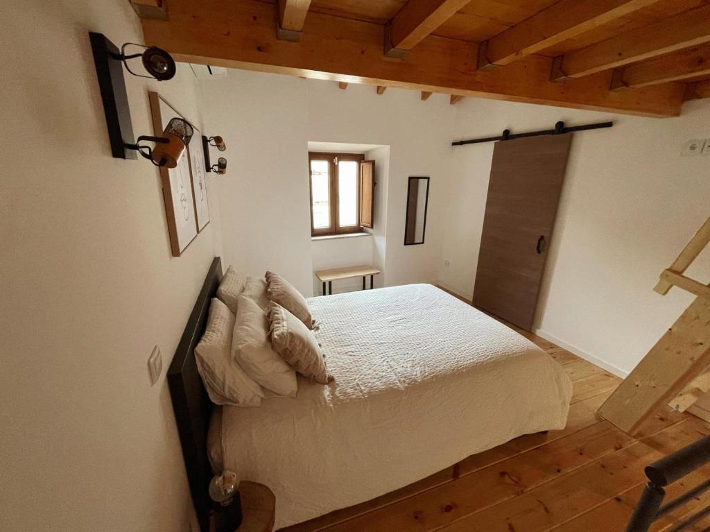 a bedroom with a bed in a room with a window at Casa do Tronco in Bragança