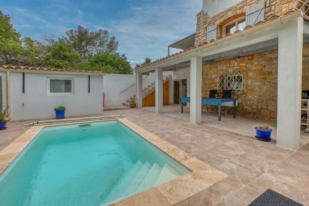 a swimming pool in front of a house at Location avec piscine & parking privé à Bandol in Bandol
