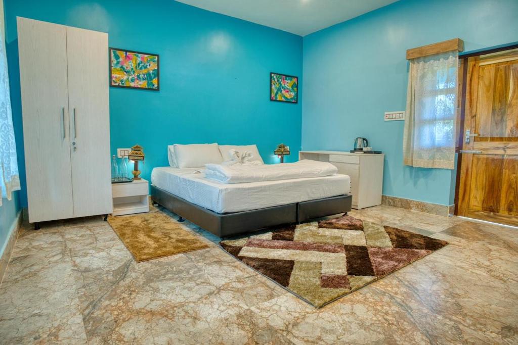 a bedroom with a bed and a blue wall at Michael's Island Resort in Sātpāra