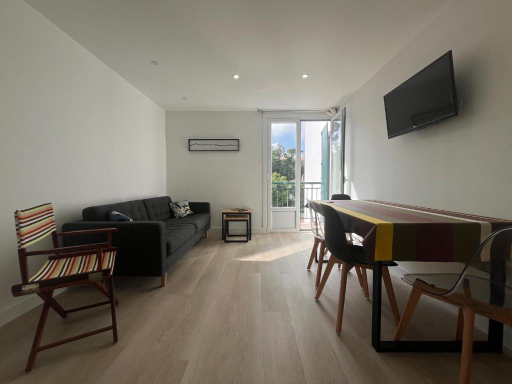 un salon avec un canapé et une table dans l'établissement Appartement rénové proche Digue Sainte-Barbe à Saint-Jean-de-Luz avec parking gratuit - FR-1-239-1073, à Saint-Jean-de-Luz