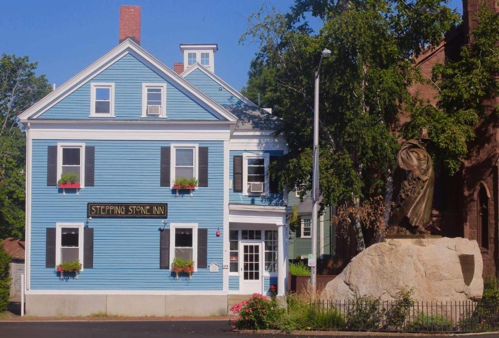 uma casa azul com uma estátua em frente em Stepping Stone Inn em Salem