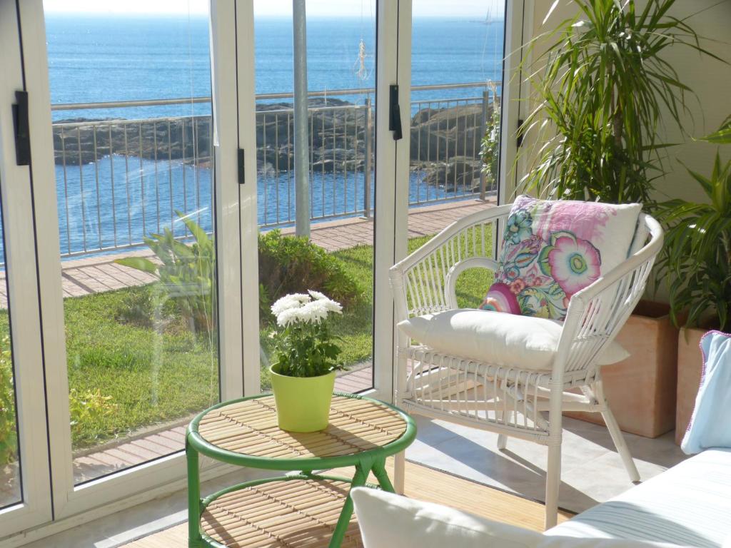 un porche con una silla y una mesa con vistas al océano en Roses sobre el Mar, en Roses