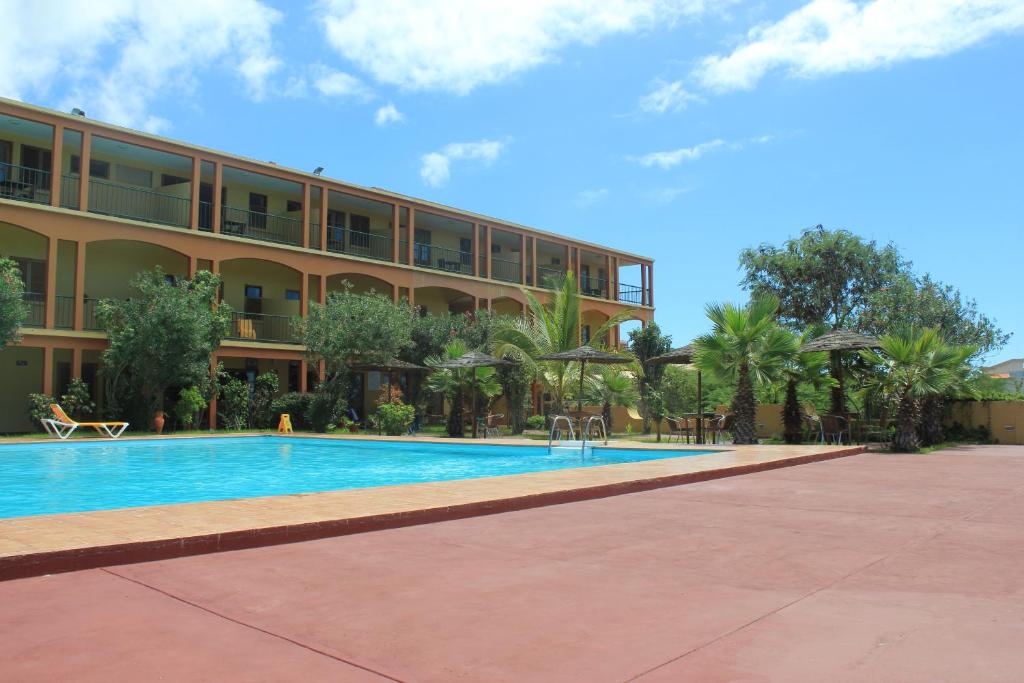 ein Hotel mit einem Pool vor einem Gebäude in der Unterkunft Bamboo Xaguate Hotel in São Filipe
