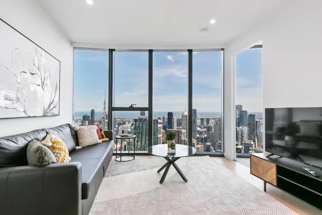 a living room with a couch and a large window at Sleek Lvl 75 Apt w Skyline Views in Aurora Complex in Melbourne