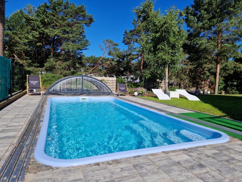 a swimming pool with a bridge in a yard at Apartamenty-Baltivia in Hel