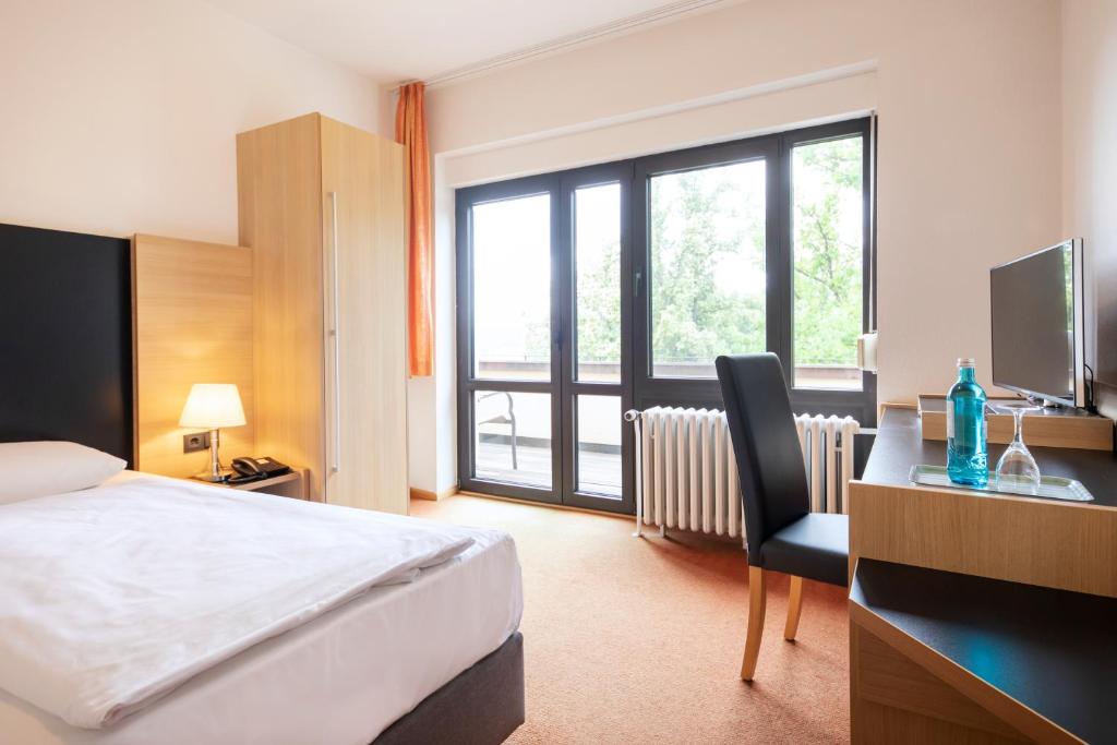 Postel nebo postele na pokoji v ubytování Roomingtons Hotel Franziskushöhe Lohr