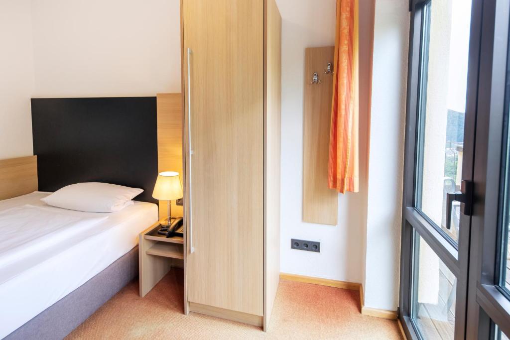 Postel nebo postele na pokoji v ubytování Roomingtons Hotel Franziskushöhe Lohr