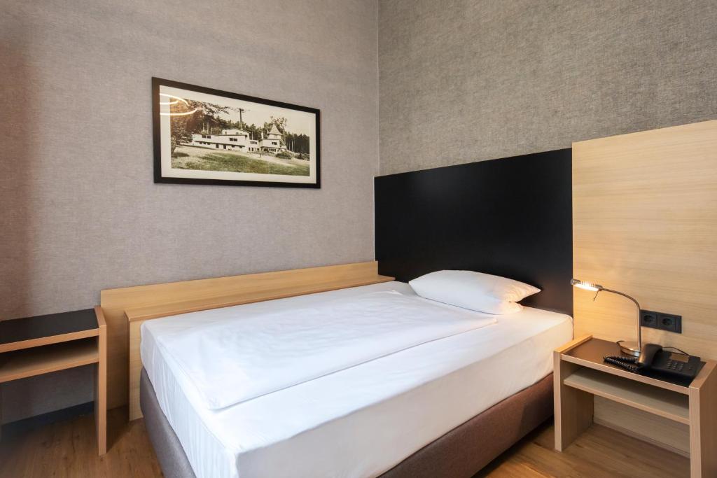 Postel nebo postele na pokoji v ubytování Roomingtons Hotel Franziskushöhe Lohr