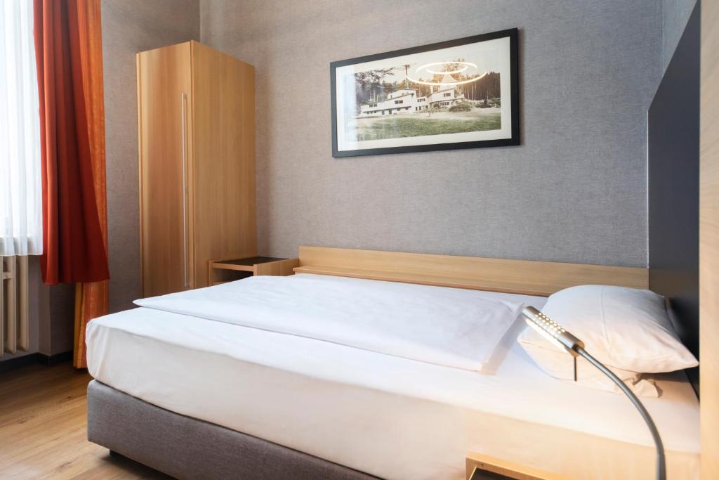 Postel nebo postele na pokoji v ubytování Roomingtons Hotel Franziskushöhe Lohr
