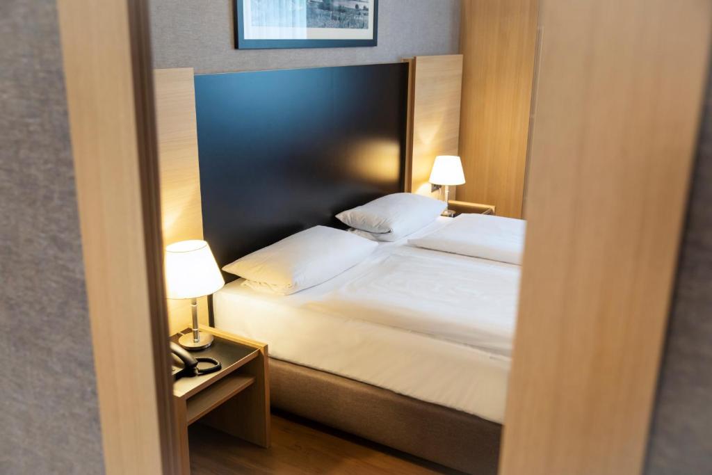 Postel nebo postele na pokoji v ubytování Roomingtons Hotel Franziskushöhe Lohr