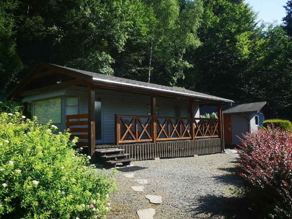 a small cabin with a porch and a fence at Śniegocinka 2 in Brenna