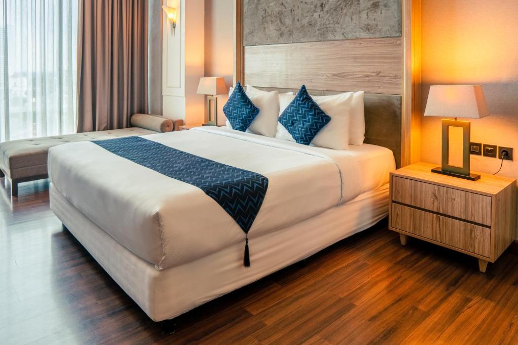 Postel nebo postele na pokoji v ubytování Azana Suites Hotel Antasari