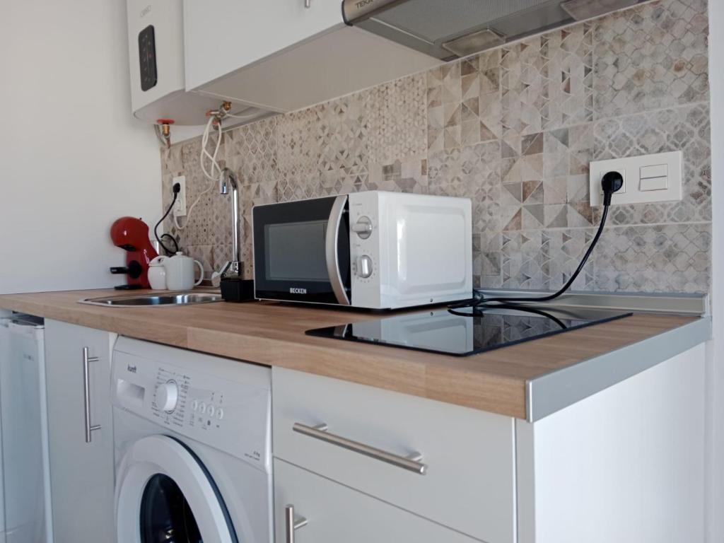 a microwave sitting on a counter in a kitchen at Apartamento Gloria Bendita in Jerez de la Frontera