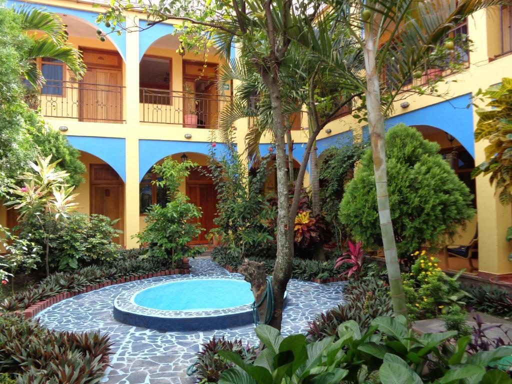 a courtyard in a hotel with a pool and trees at Hotel Los Arcos in Estelí