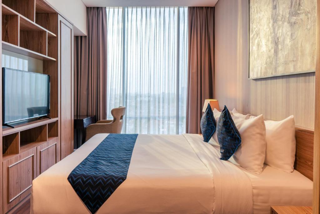 Postel nebo postele na pokoji v ubytování Azana Suites Hotel Antasari