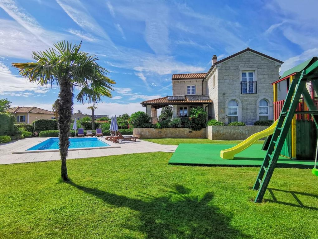 un cortile con scivolo e parco giochi di Family Villa Blum a Dobrinj