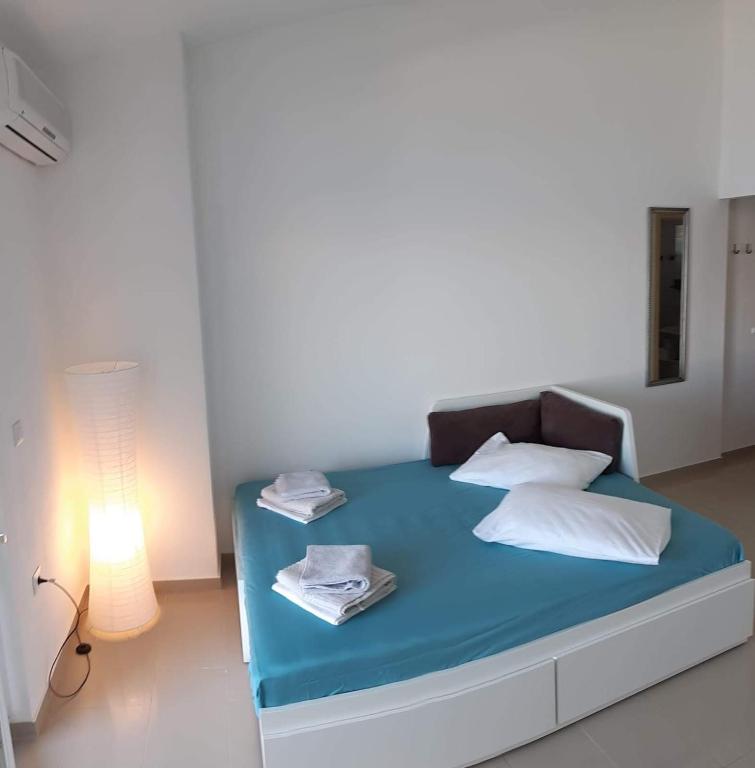 łóżko z niebieską pościelą i białymi poduszkami w pokoju w obiekcie Apartment Zvonko w mieście Metajna