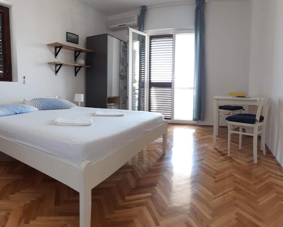 - duże białe łóżko w pokoju z drewnianą podłogą w obiekcie Apartment Zvonko w mieście Metajna