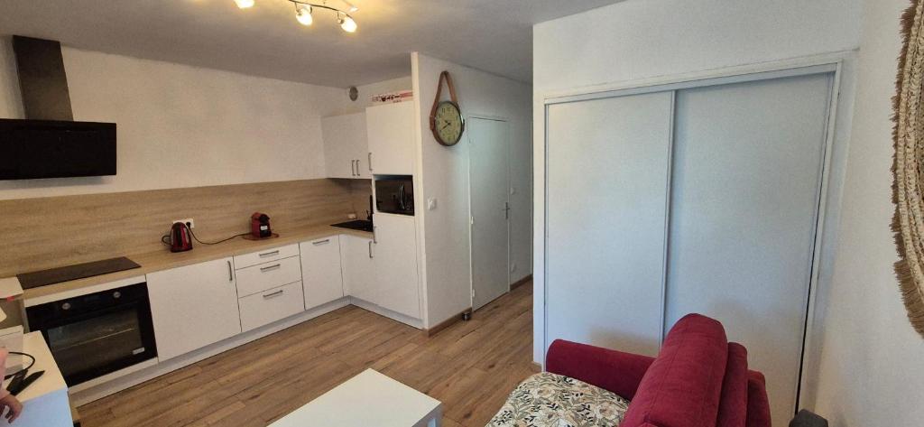 un salon avec un canapé et une cuisine dans l'établissement Apartement bord de mer parking terasse, à La Ciotat