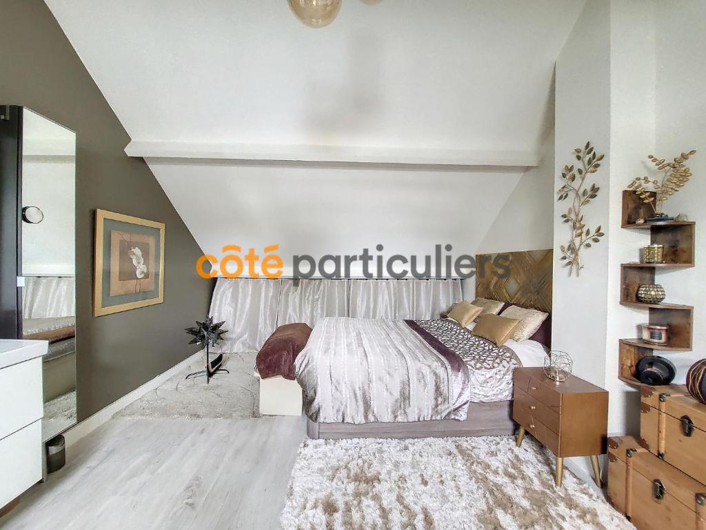 une chambre avec un lit et un mur blanc dans l'établissement Maison duplex à Saint-Maur-des-Fossés 87m2, à Saint-Maur-des-Fossés