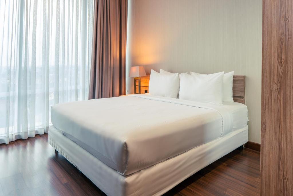 Postel nebo postele na pokoji v ubytování Azana Suites Hotel Antasari
