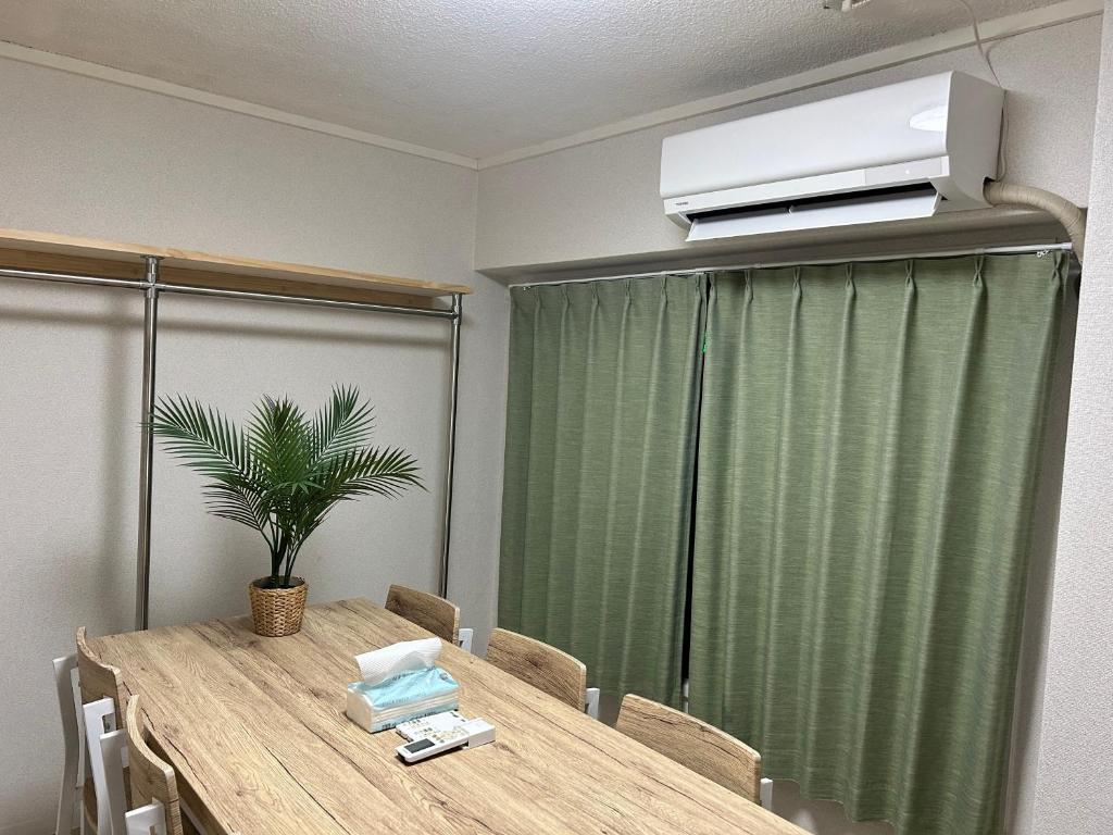 Cette chambre dispose d'une table et d'une télévision murale. dans l'établissement Riverside Omori, à Tokyo