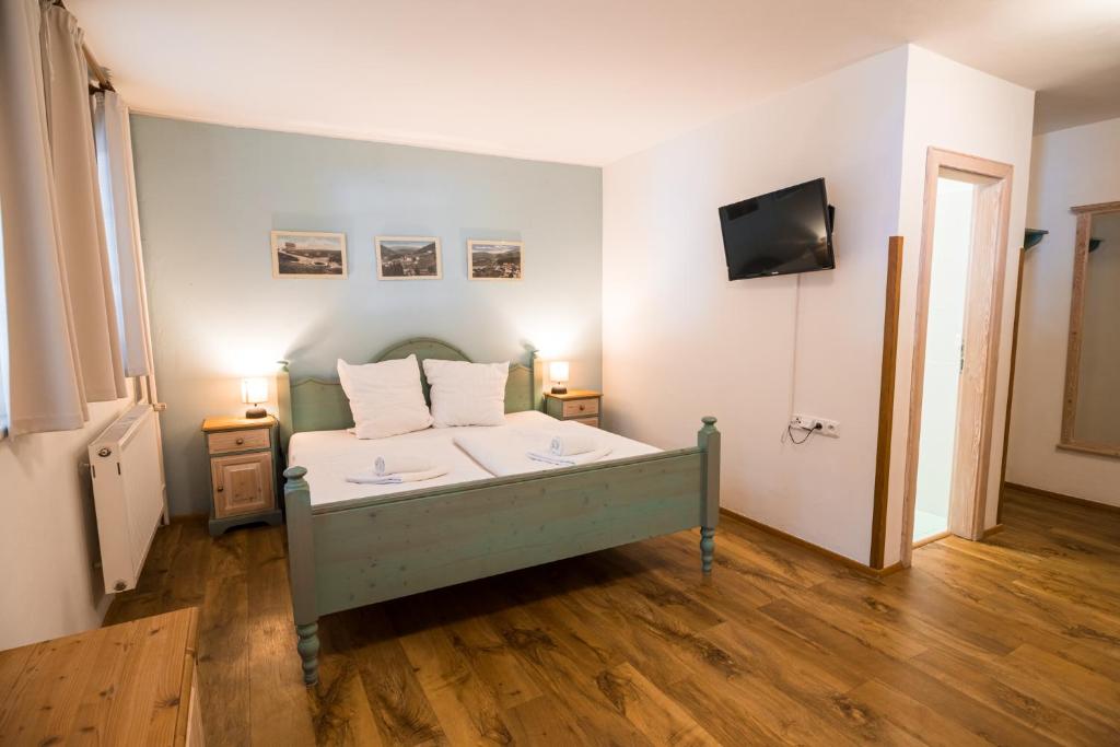 sypialnia z łóżkiem i telewizorem na ścianie w obiekcie Grand Apartments Špindlerův Mlýn w Szpindlerowym Młynie