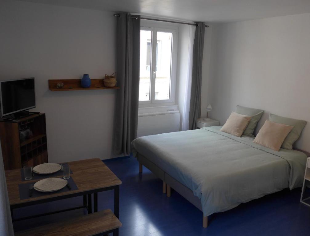 une chambre avec un lit, une table et une fenêtre dans l'établissement Studio 27m2 centre-ville, à Bourges